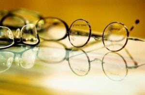 several pairs of glasses on a glass top surface