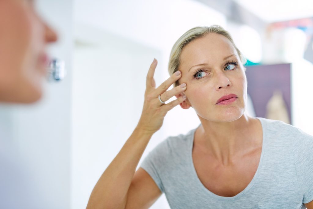 Cropped shot of a mature woman inspecting her skin in front of the bathroom mirror