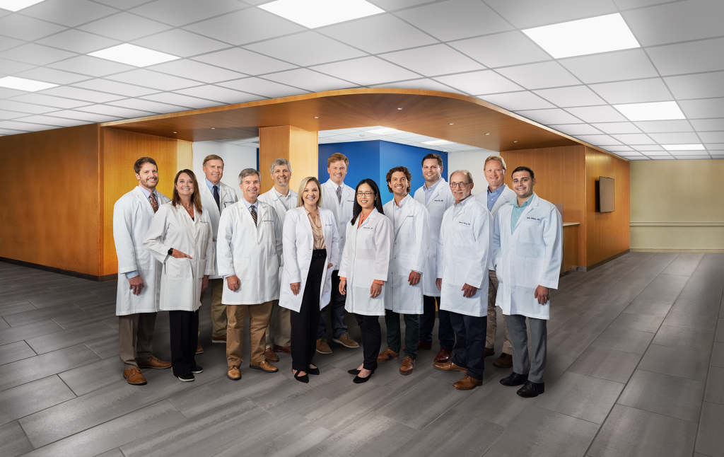 Group of diverse doctors in white costs stand in two rows.