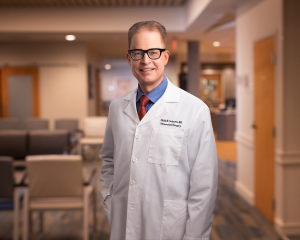 Smiling male doctor with glasses in a white coat